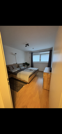 Schlafzimmer der Maisonettewohnung in Neudörfl mit Doppelbett, Holzboden und Verdunkelungsvorhang