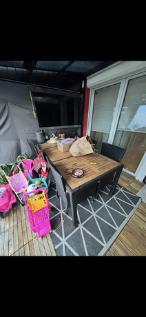 Überdachte Terrasse der Maisonettewohnung in Neudörfl mit Gartenmöbeln und Holzboden