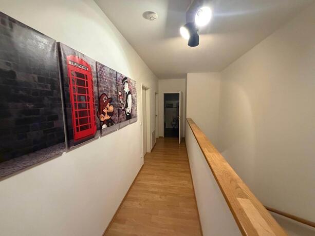 Reihenhaus Pinkafeld Galerie – Gang im Obergeschoss mit Holzhandlauf und Zugang zu den Zimmern