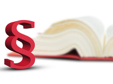 Stock Foto Gesetzesklammer mit Buch im Hintergrund