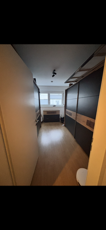 Begehbarer Kleiderschrank im Obergeschoss der Maisonettewohnung Neudörfl mit Schiebetüren in Anthrazit