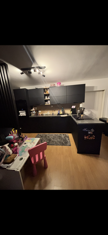 Moderne schwarze Einbauküche mit Kochblock und Hängeschränken in der Maisonettewohnung Neudörfl