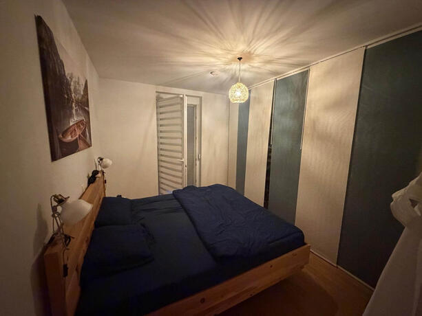 Reihenhaus Pinkafeld Schlafzimmer – Doppelbett aus Holz mit Einbauschrank und Fenster