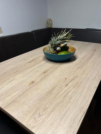 Nahaufnahme der Holztischplatte mit Obstschale auf Eckbank